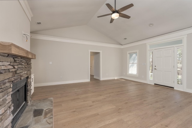 unfurnished living room featuring a stone fireplace, vaulted ceiling, light hardwood / wood-style floors, and ceiling fan