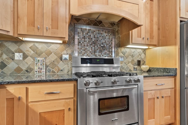 kitchen with tasteful backsplash, exhaust hood, dark stone counters, and appliances with stainless steel finishes