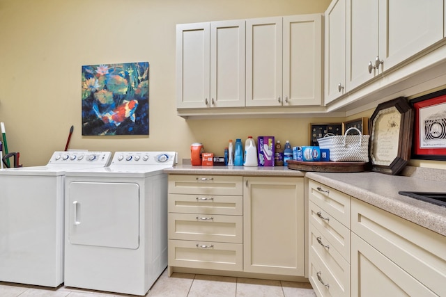 laundry room featuring separate washer and dryer, cabinets, and light tile patterned flooring