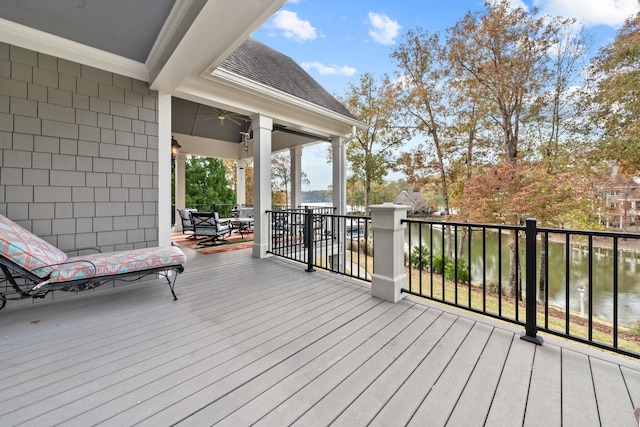 wooden deck featuring a water view and ceiling fan