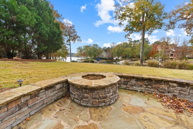 view of patio / terrace with a fire pit and a water view