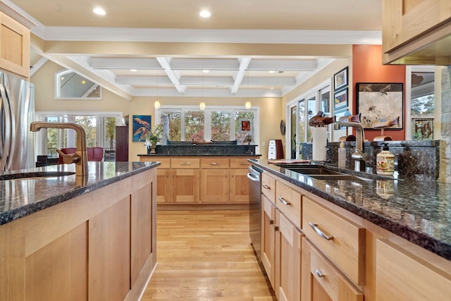 kitchen with appliances with stainless steel finishes, pendant lighting, beamed ceiling, sink, and light brown cabinets