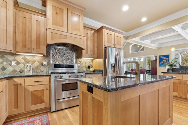 kitchen with stainless steel appliances, sink, light hardwood / wood-style flooring, and dark stone countertops