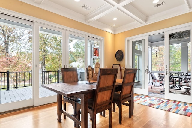 dining area featuring beamed ceiling, ornamental molding, coffered ceiling, and light hardwood / wood-style flooring