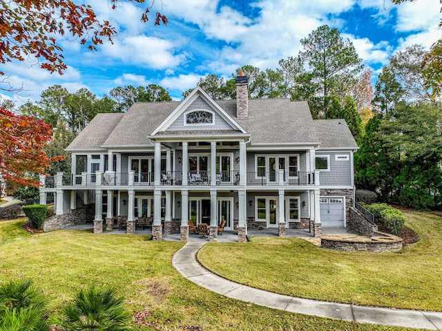 rear view of house featuring a garage, a patio, a lawn, and french doors