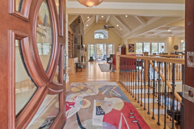 corridor with beamed ceiling, high vaulted ceiling, and light wood-type flooring