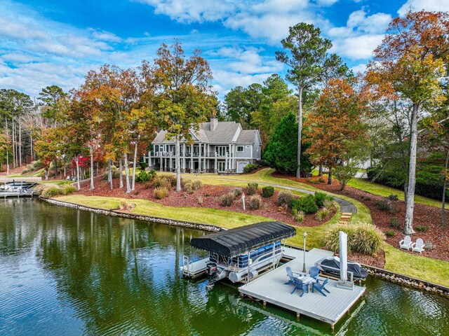 view of dock with a lawn and a water view