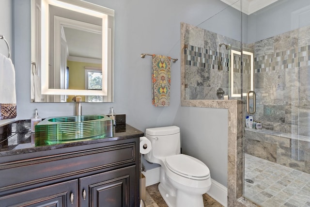 bathroom featuring vanity, a shower with shower door, ornamental molding, and toilet