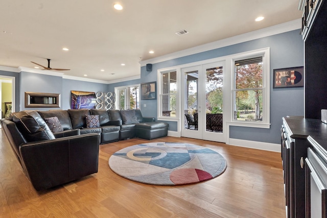 living room with crown molding, french doors, ceiling fan, and light wood-type flooring