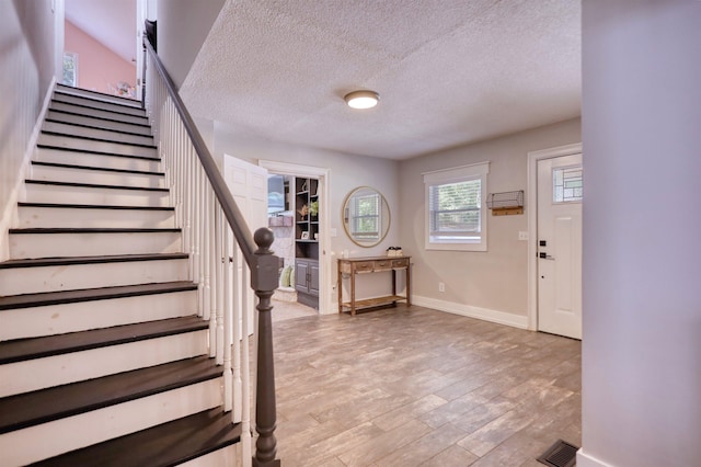 222 River Bend Dr, Eatonton, GA 31024 - foyer entrance with stairway, a textured ceiling, and light wood-type flooring