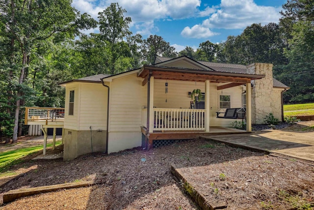 222 River Bend Dr, Eatonton, GA 31024 - view of front of home featuring covered porch, stone siding, and view of wooded area