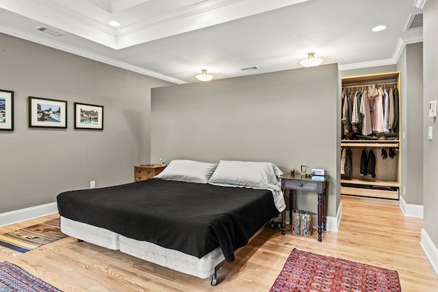 bedroom featuring crown molding, wood finished floors, a closet, baseboards, and recessed lighting