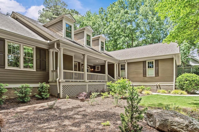 view of front of home featuring covered porch and a shingled roof