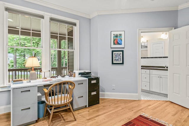 office space featuring ornamental molding, baseboards, plenty of natural light, and light wood finished floors