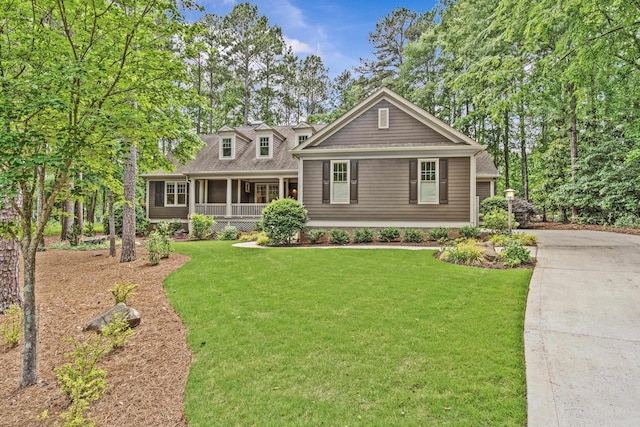 view of front facade with a front yard, a sunroom, and driveway