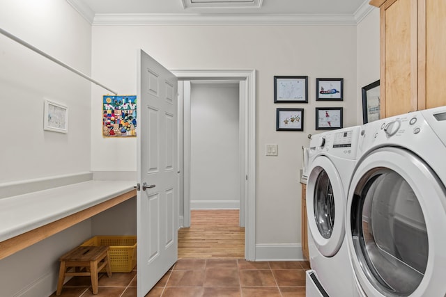 laundry area featuring washer and dryer, ornamental molding, cabinet space, tile patterned floors, and baseboards