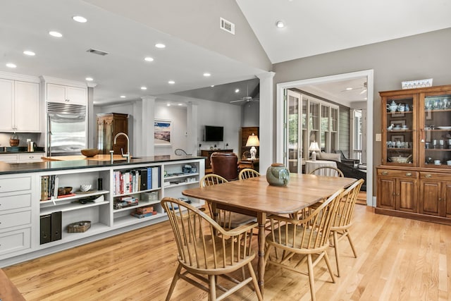 dining space featuring a ceiling fan, light wood-style flooring, recessed lighting, lofted ceiling, and ornate columns