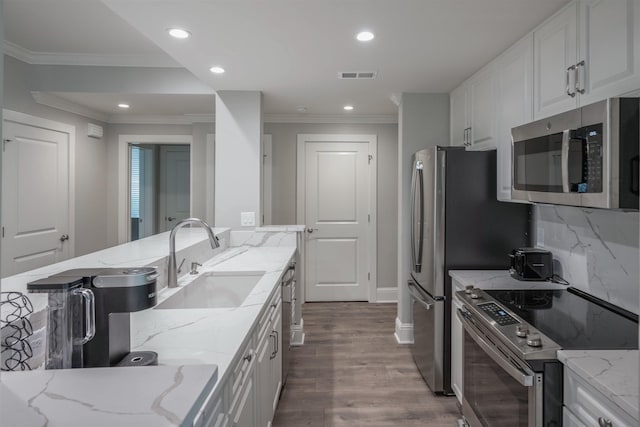 kitchen featuring appliances with stainless steel finishes, sink, white cabinets, dark hardwood / wood-style flooring, and light stone counters