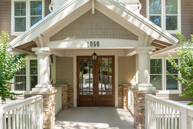 entrance to property featuring covered porch and french doors