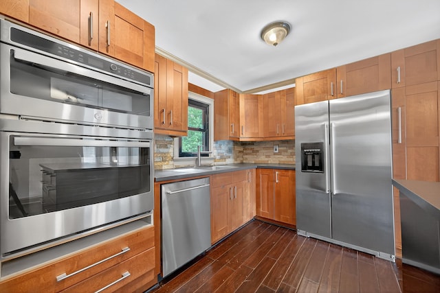 128 Turtle Ct, Eatonton, GA 31024 - kitchen with appliances with stainless steel finishes, dark wood finished floors, tasteful backsplash, brown cabinetry, and dark countertops