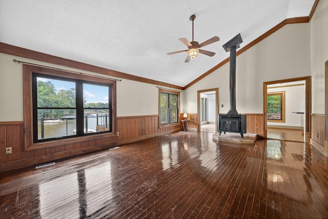 128 Turtle Ct, Eatonton, GA 31024 - unfurnished living room with a wainscoted wall, a wood stove, hardwood / wood-style floors, ceiling fan, and a textured ceiling