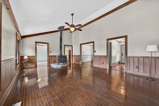128 Turtle Ct, Eatonton, GA 31024 - living area with ceiling fan, a wood stove, wainscoting, hardwood / wood-style floors, and wood walls