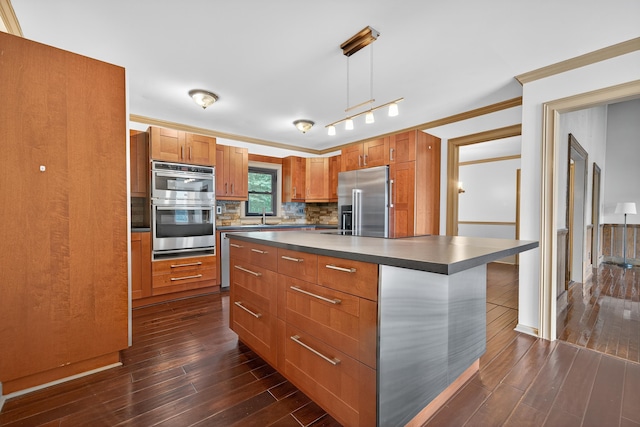 128 Turtle Ct, Eatonton, GA 31024 - kitchen featuring appliances with stainless steel finishes, dark countertops, dark wood-style flooring, backsplash, and crown molding