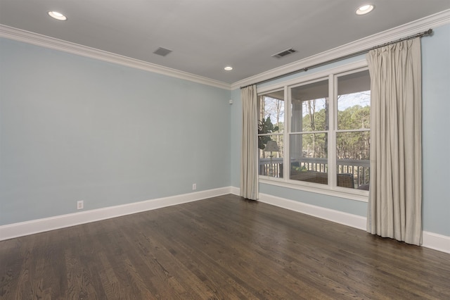 spare room with ornamental molding and dark hardwood / wood-style floors