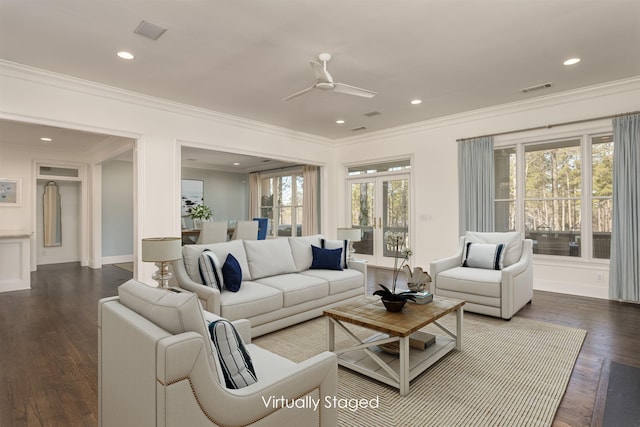 living room with ornamental molding, dark wood-type flooring, and ceiling fan