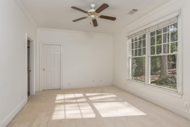 empty room featuring ornamental molding, light carpet, and a wealth of natural light