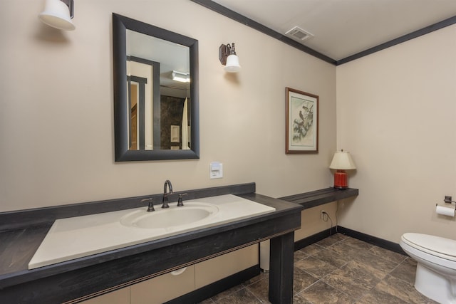 bathroom with sink, crown molding, and toilet