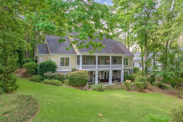 back of house with a patio area, a sunroom, and a lawn