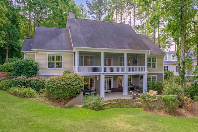 back of house featuring a yard, a patio, and french doors