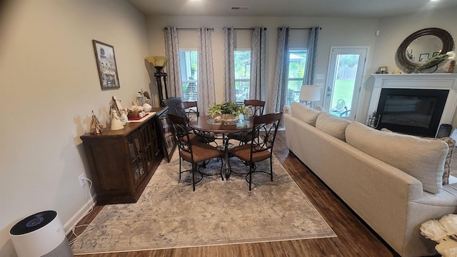  - dining space with wood finished floors, a glass covered fireplace, and baseboards
