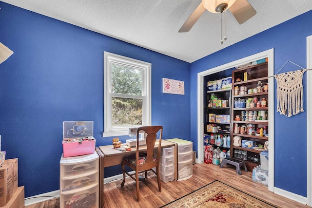 office featuring ceiling fan, wood-type flooring, and a textured ceiling