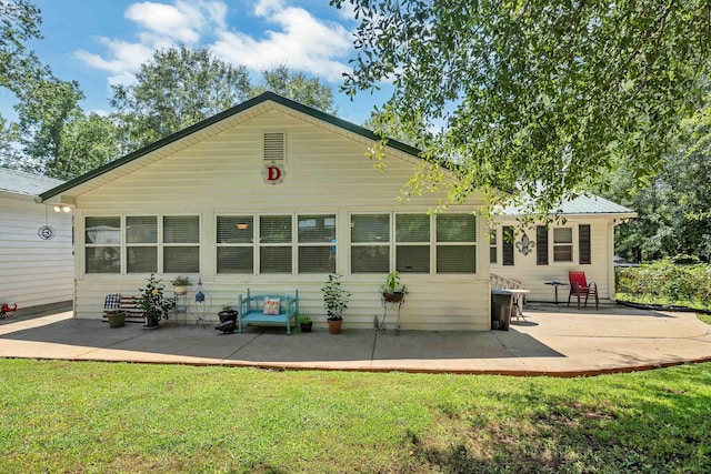 back of house with a patio and a lawn