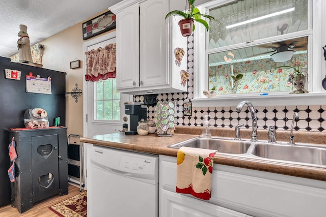 kitchen with white cabinetry, dishwasher, sink, and light hardwood / wood-style flooring