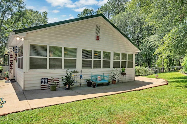 back of house featuring a patio area and a lawn