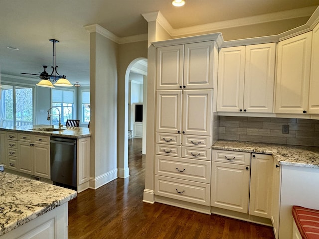 kitchen featuring dishwashing machine, white cabinets, arched walkways, and a sink