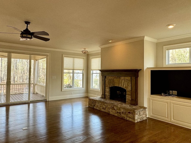 unfurnished living room featuring plenty of natural light, dark wood finished floors, a fireplace, and ornamental molding