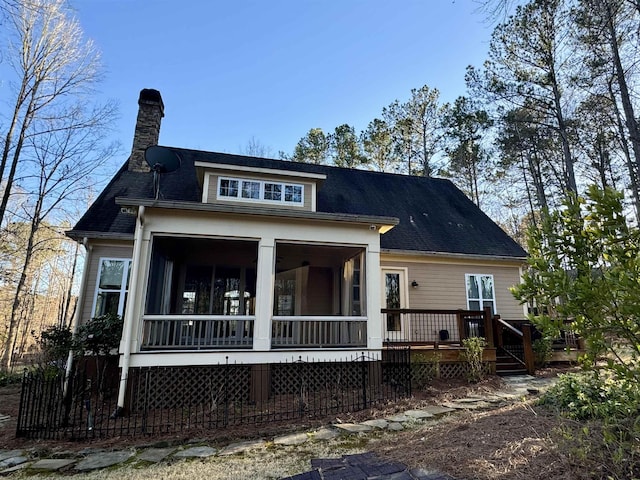 view of front of home featuring a sunroom and a chimney