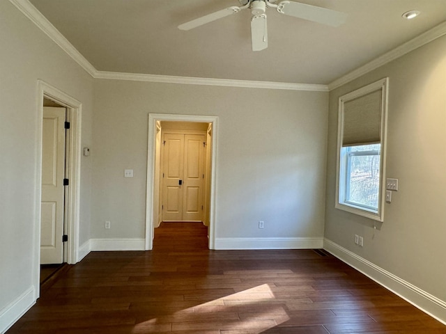 unfurnished room with ceiling fan, crown molding, baseboards, and wood finished floors