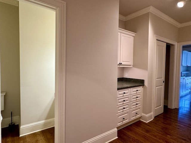 interior space with dark wood finished floors, crown molding, and baseboards