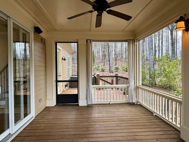 unfurnished sunroom featuring a ceiling fan