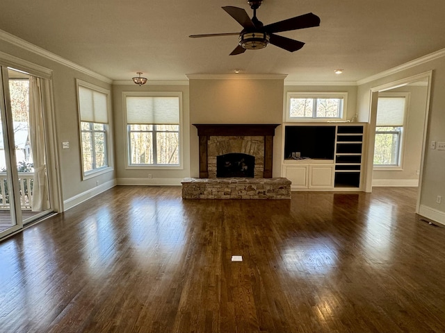 unfurnished living room featuring dark wood-style floors, a healthy amount of sunlight, and ornamental molding