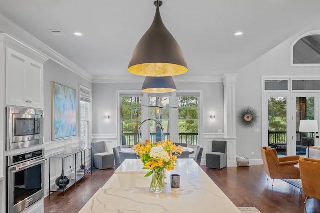 dining area with crown molding, decorative columns, and dark hardwood / wood-style floors