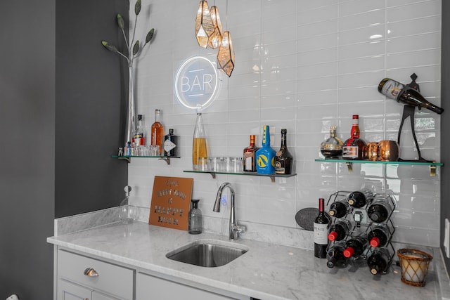 kitchen featuring white cabinetry, light stone countertops, sink, and tasteful backsplash