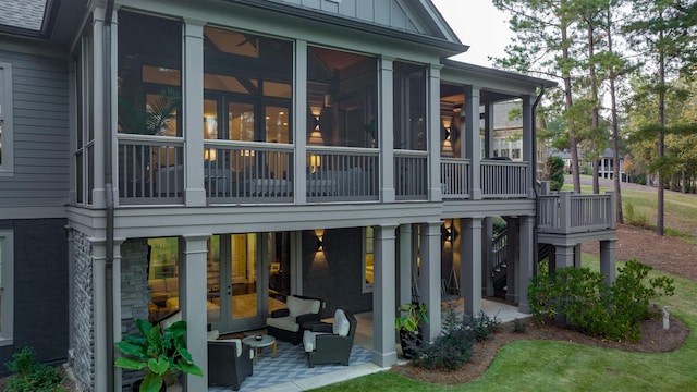 back of property featuring an outdoor living space and a sunroom