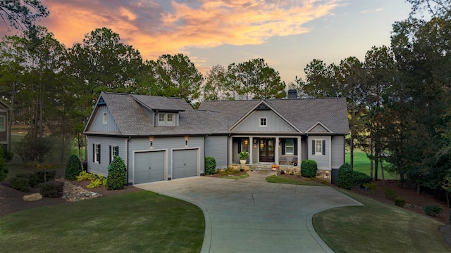 view of front of home featuring a porch, a garage, and a yard