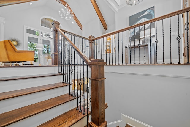 stairs featuring high vaulted ceiling and a chandelier